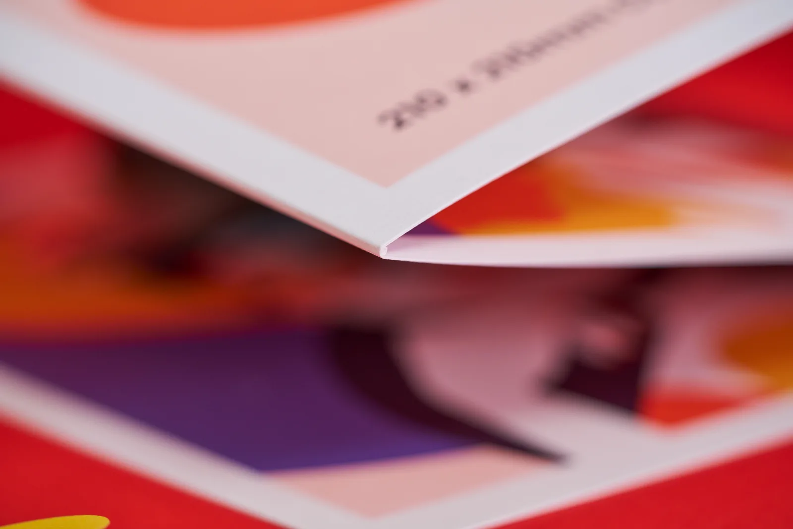 Close up of a 210 x 210mm 210 x 210mm printed concertina leaflet showing the detail of the fold on a bright red background