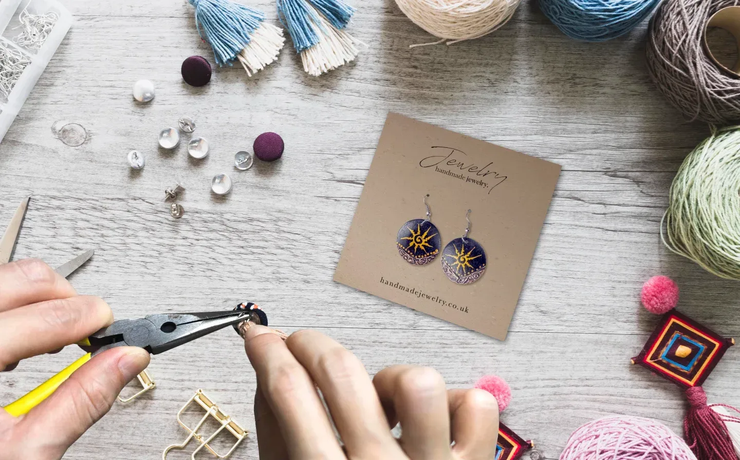 A person skillfully uses pliers to create jewellery with a jewellery card on the table 