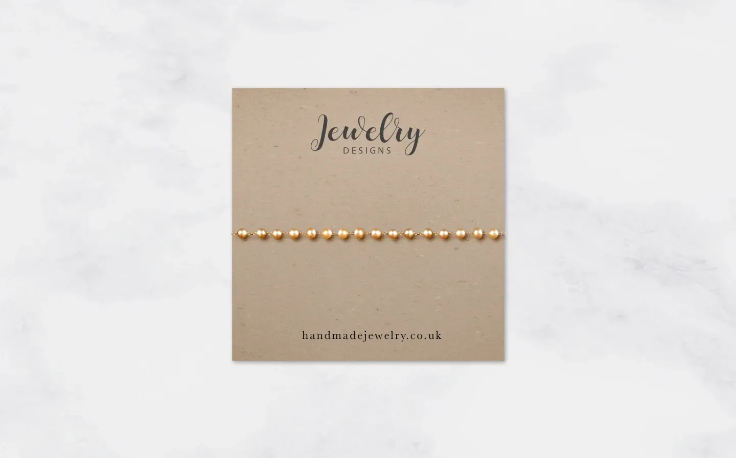 A golden bracelet, made from beads, displayed on a rustic jewellery card