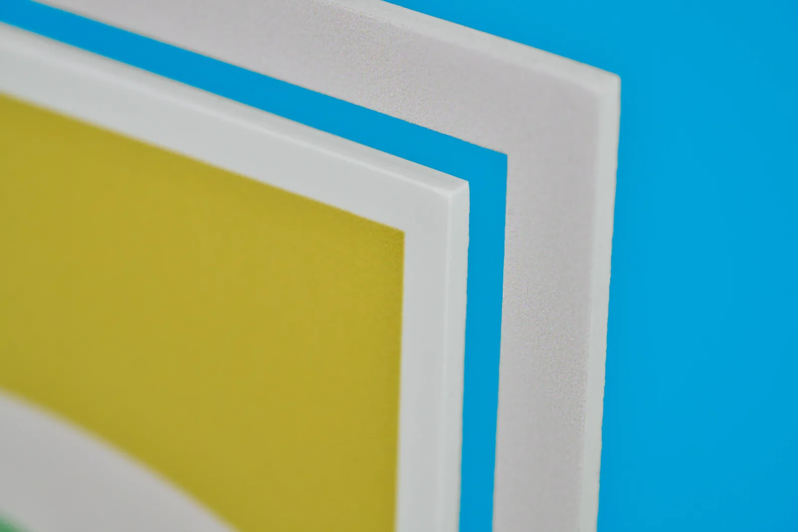 close up detail of the corner of a 3mm foamex printed exhibition graphic on a bright blue background