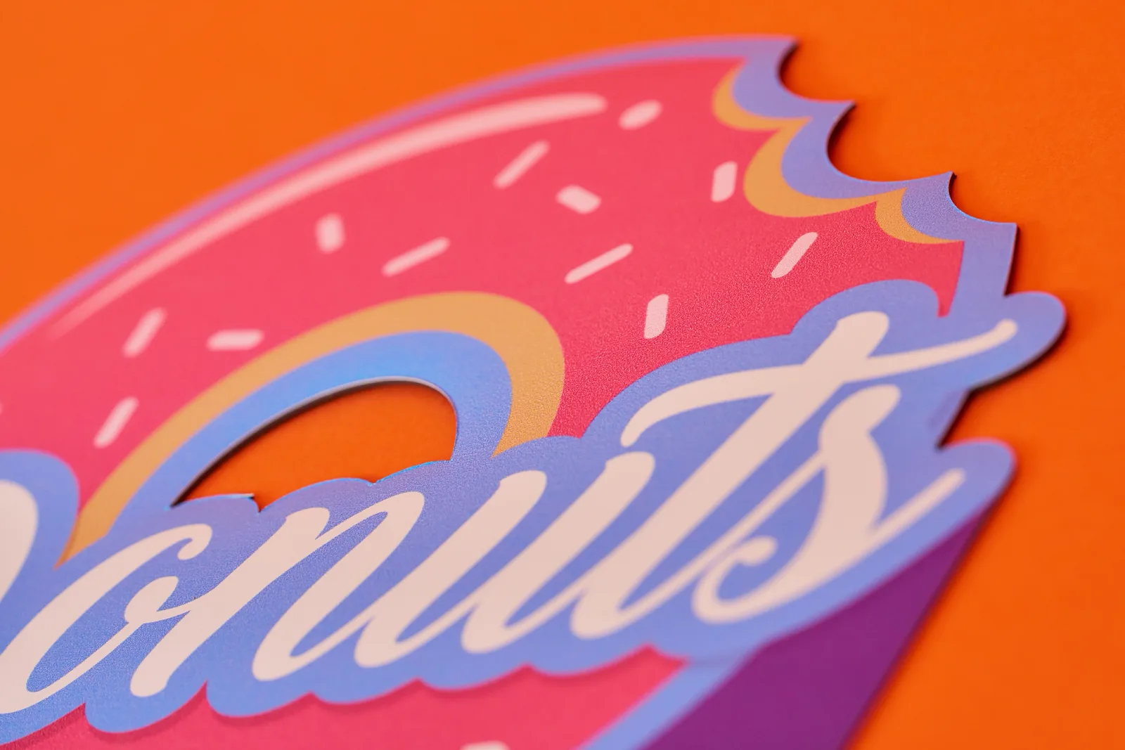 cut to shape printed magnetic van sign with wording 'donuts' on a bright orange background
