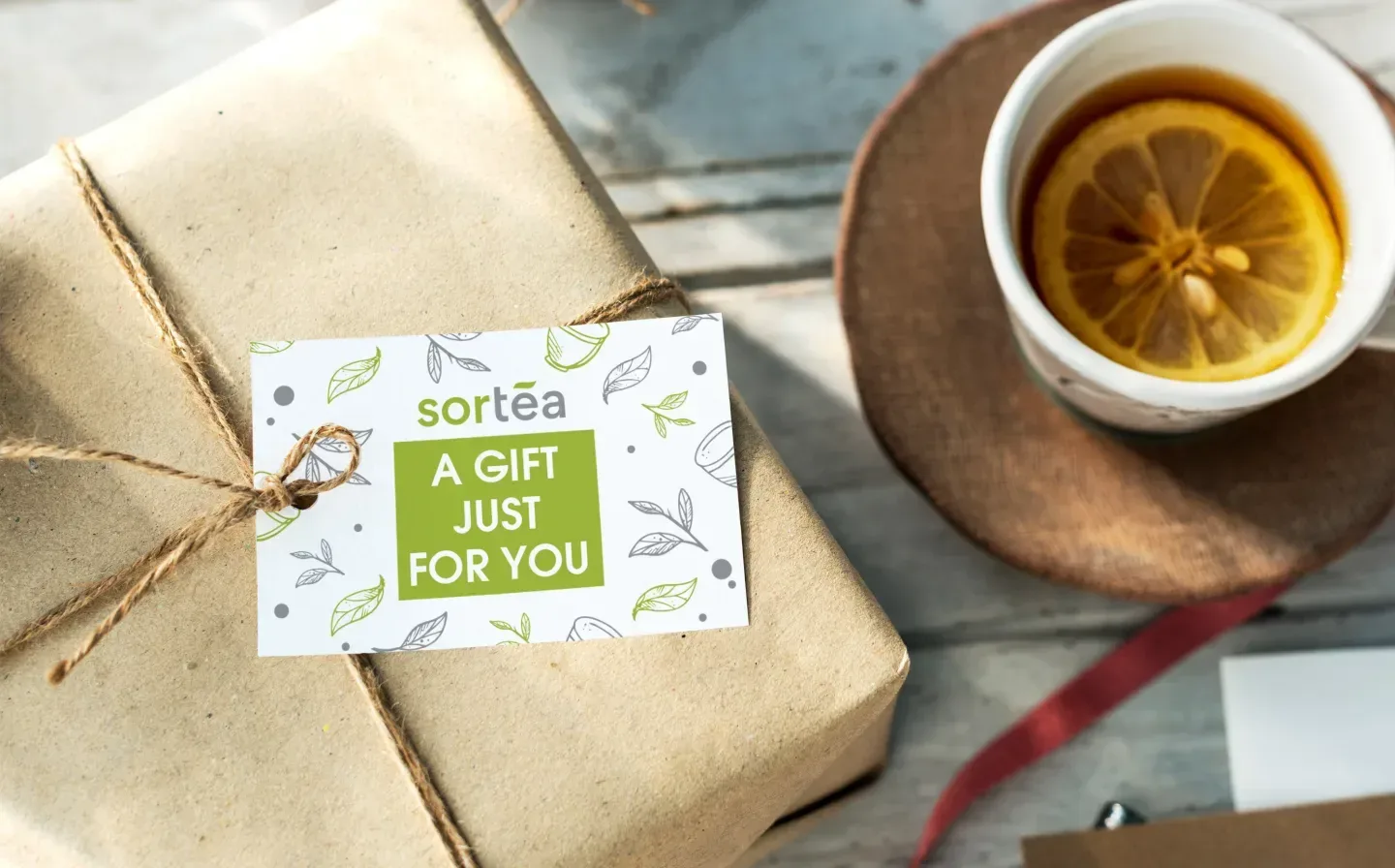 A wrapped package featuring a gift tag that says "A Gift Just For You" next to a beverage