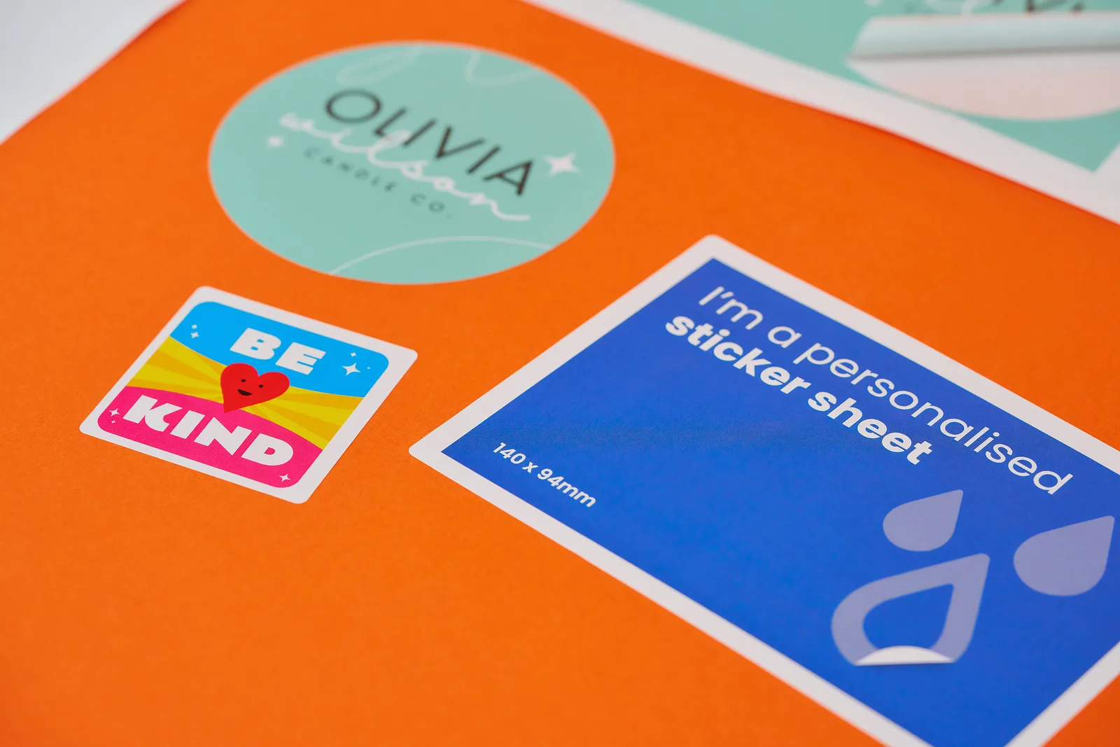 green circle sticker, blue yellow and red square sticker and a blue rectangle sticker with text 'i'm a personalised sticker sheet' on a bright orange background