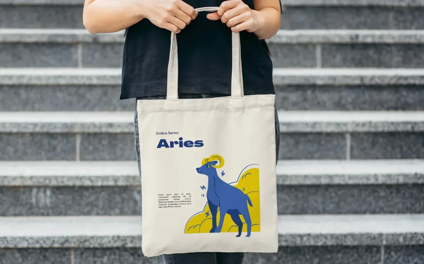 A woman proudly holds a tote bag adorned with the Aries zodiac symbol
