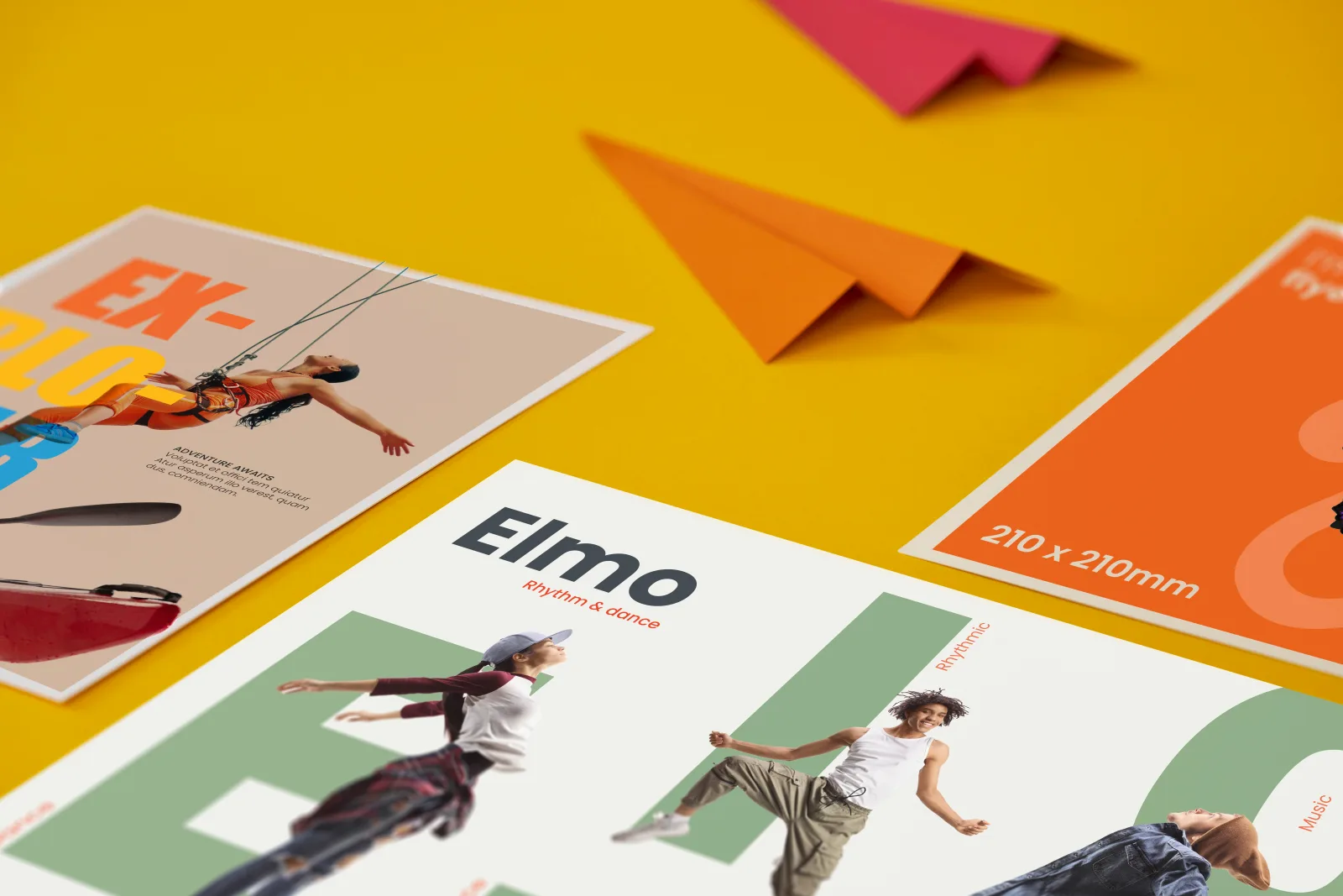 Close up of 3 printed premium flyers, A6 portrait, A4 landscape with wording 'elmo' and 3 dancers and a 210x210mm bright orange flyer on a bright yellow background with 1 red paper airplane 