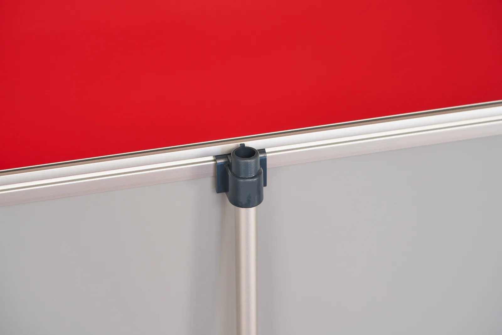 back of a budget roller banner graphic showing support ole connected to the metal top rail on a bright red background