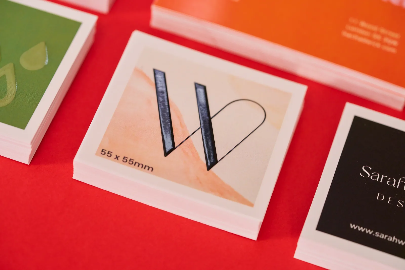 stack of business cards with black letter w with spot uv on bright red background