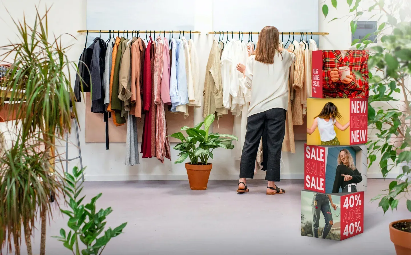 A stack of display cubes showcasing a sale, with a woman examining clothing in the background