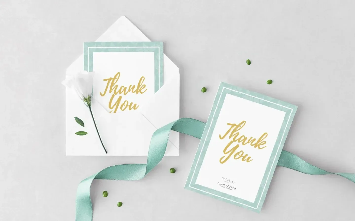 A wedding thank you card displayed in an elegant envelope, adorned with a decorative ribbon